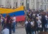 Venezuelanos comemoram prisão de Maduro em frente à escadaria da UFPR, após instituição publicar nota criticando ataque americano.