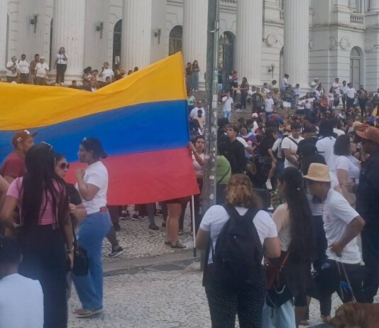 Venezuelanos comemoram prisão de Maduro em frente à escadaria da UFPR, após instituição publicar nota criticando ataque americano.